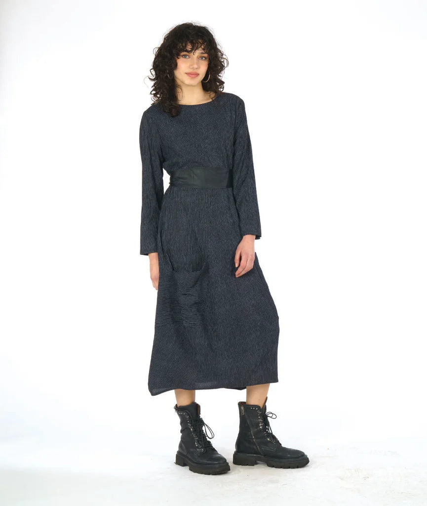 Woman wearing a dark grey dress with long sleeves on a white background