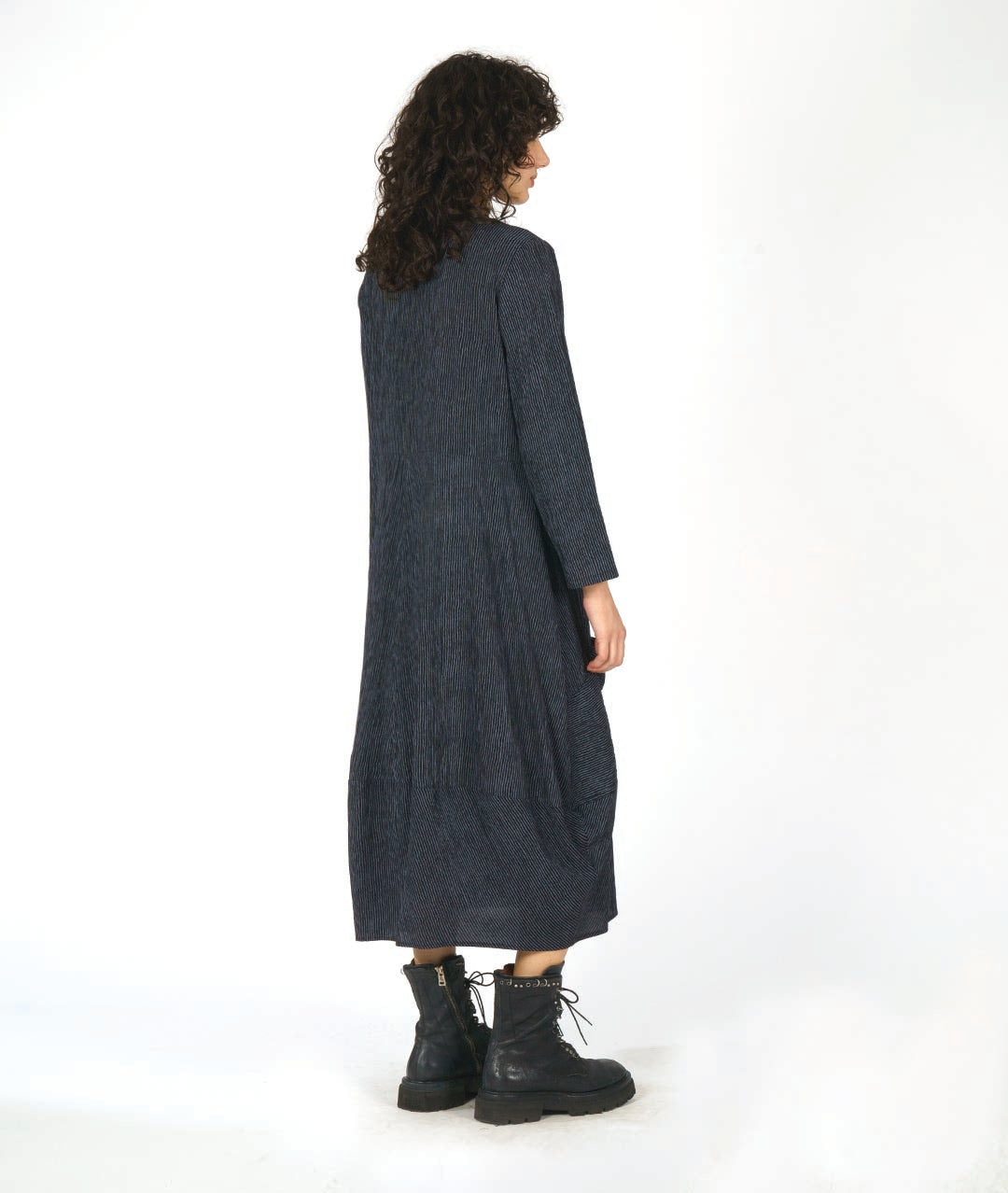 model in a black and grey dress with contrasting angled panels, oversized pockets, and long sleeves