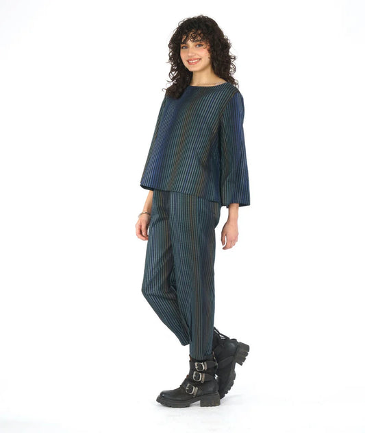 model wearing a dark blue striped outfit with black boots on a white background