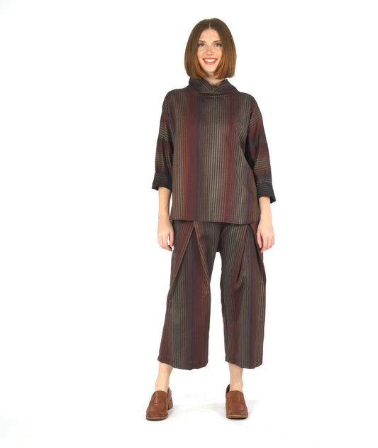 model wearing a striped soft cowl neck 3/4 sleeve top with front pleated pants on a white background