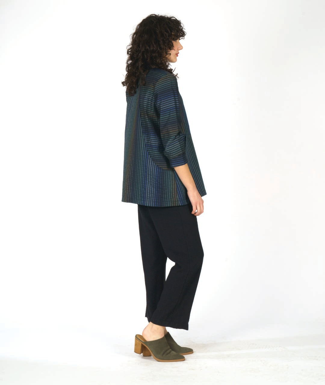 model in a multi tonal blue striped jacket with contrasting panels of stripe direction. worn with black pants