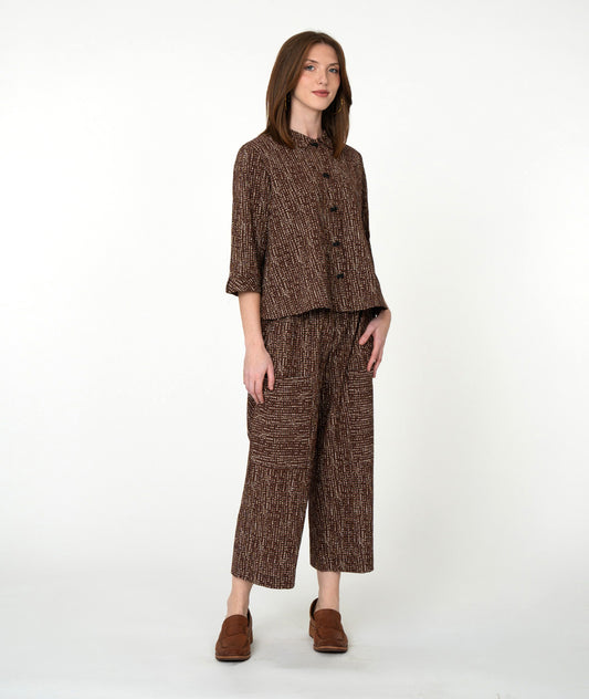 Woman wearing a brown patterned outfit on a white background