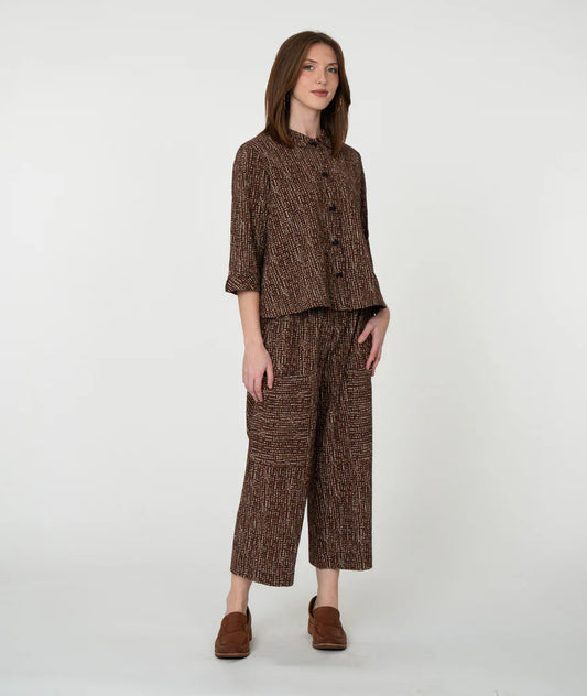 Woman wearing a brown patterned outfit on a white background