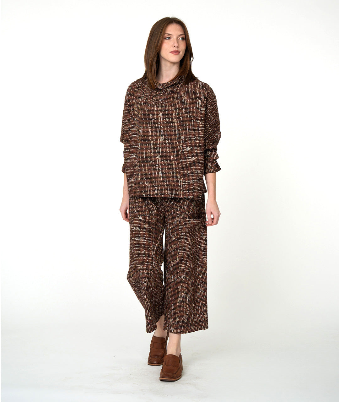 Woman wearing a brown textured outfit on a white background