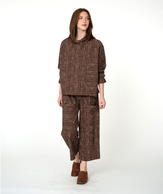 Woman wearing a brown textured outfit on a white background