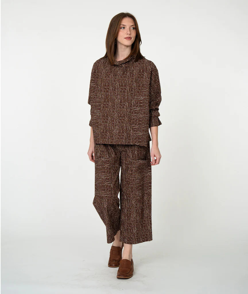 Woman wearing a brown textured outfit on a white background