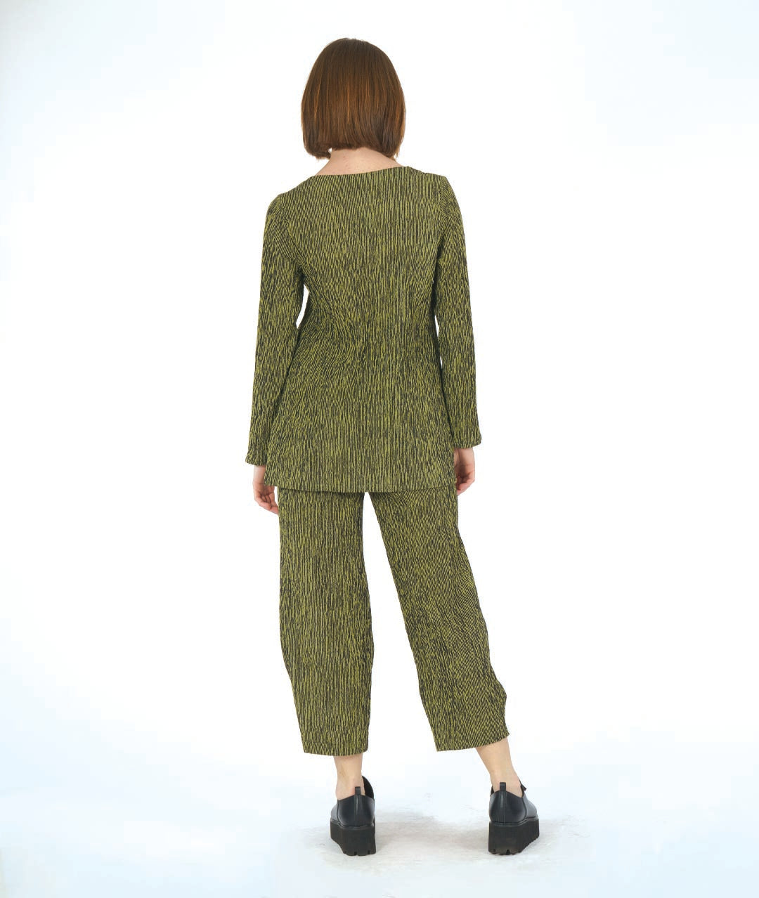 model in a black and green striped pant with a matching top with a contrasting panel. pant has a tulip shape