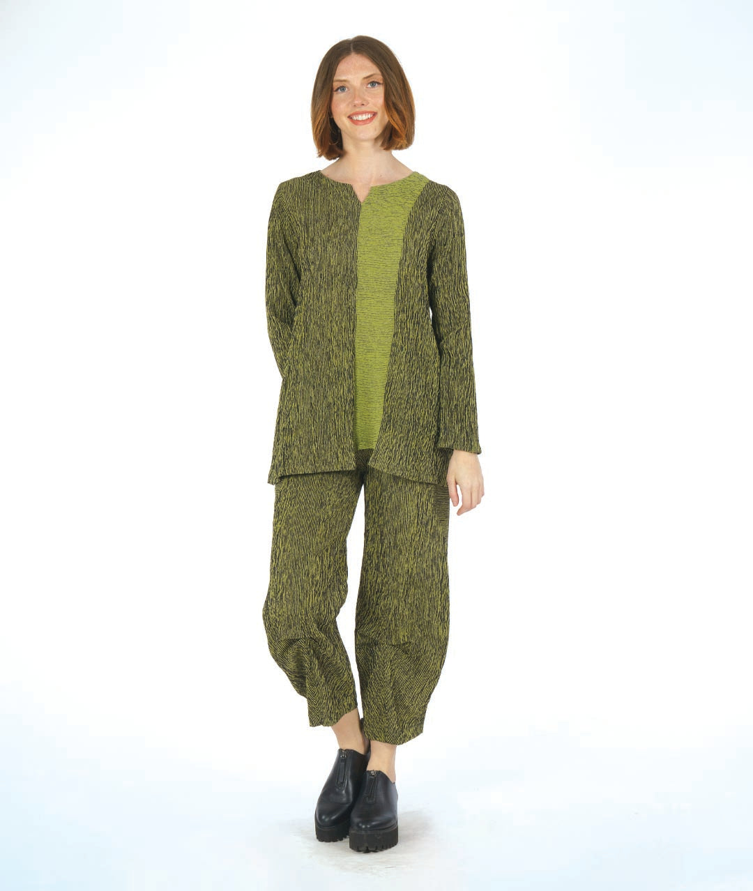 model in a black and green striped pant with a matching top with a contrasting panel. pant has a tulip shape