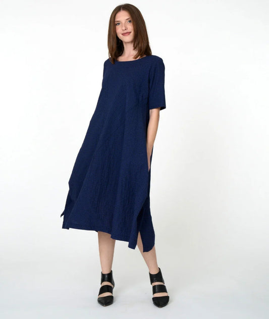 model wearing blue striped dress with mid sleeves and lack shoes against white background