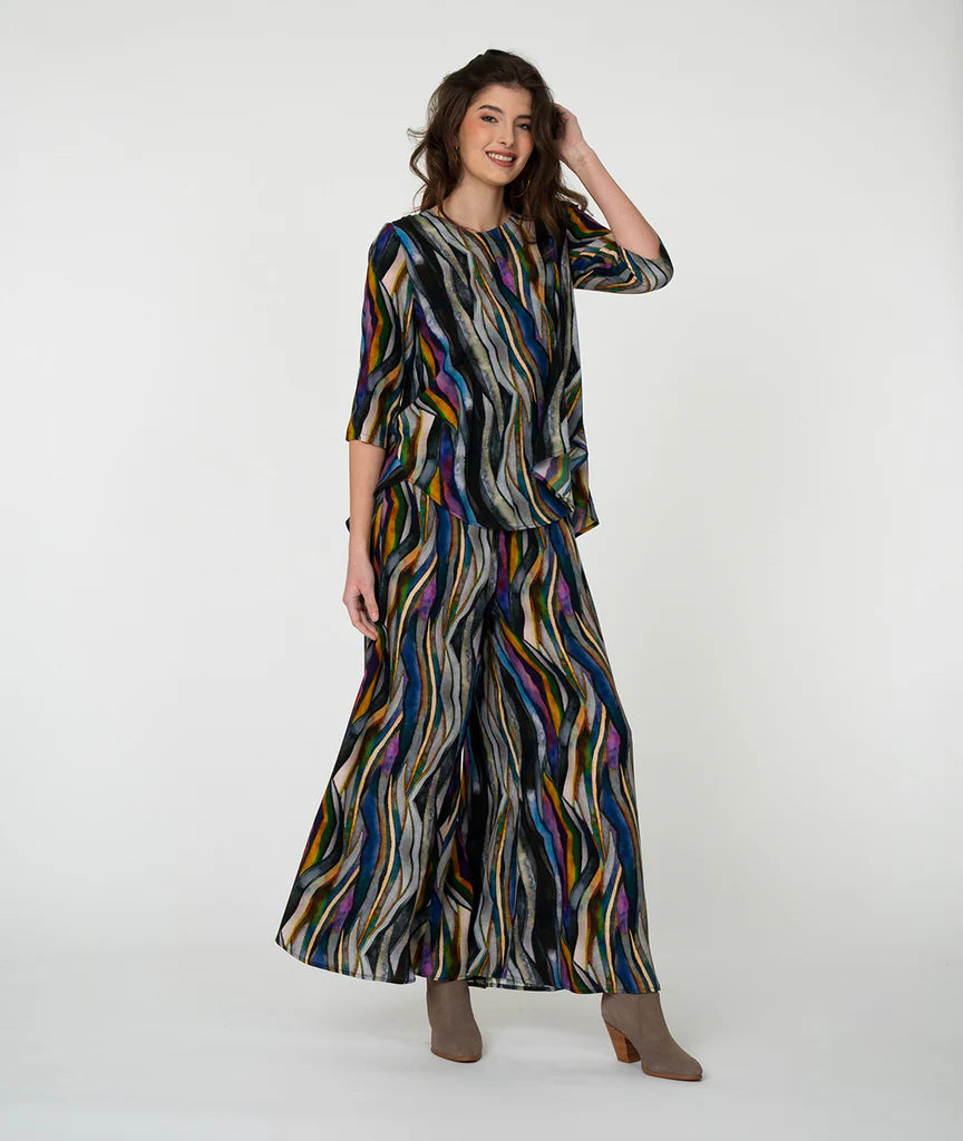 Model wearing 'watercolor' pattern top and pants with white background.