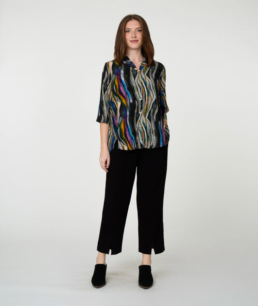 model in a slim black pant with a multi color striped blouse