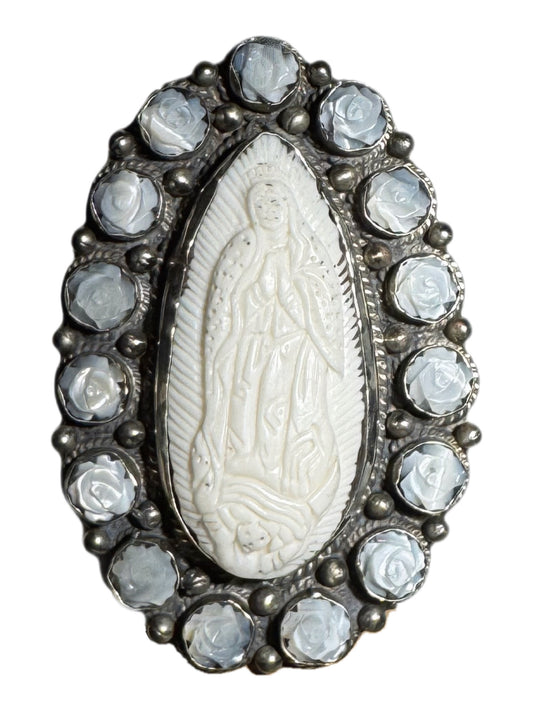 Guadalupe ring with a central white stone and silver setting on a white background