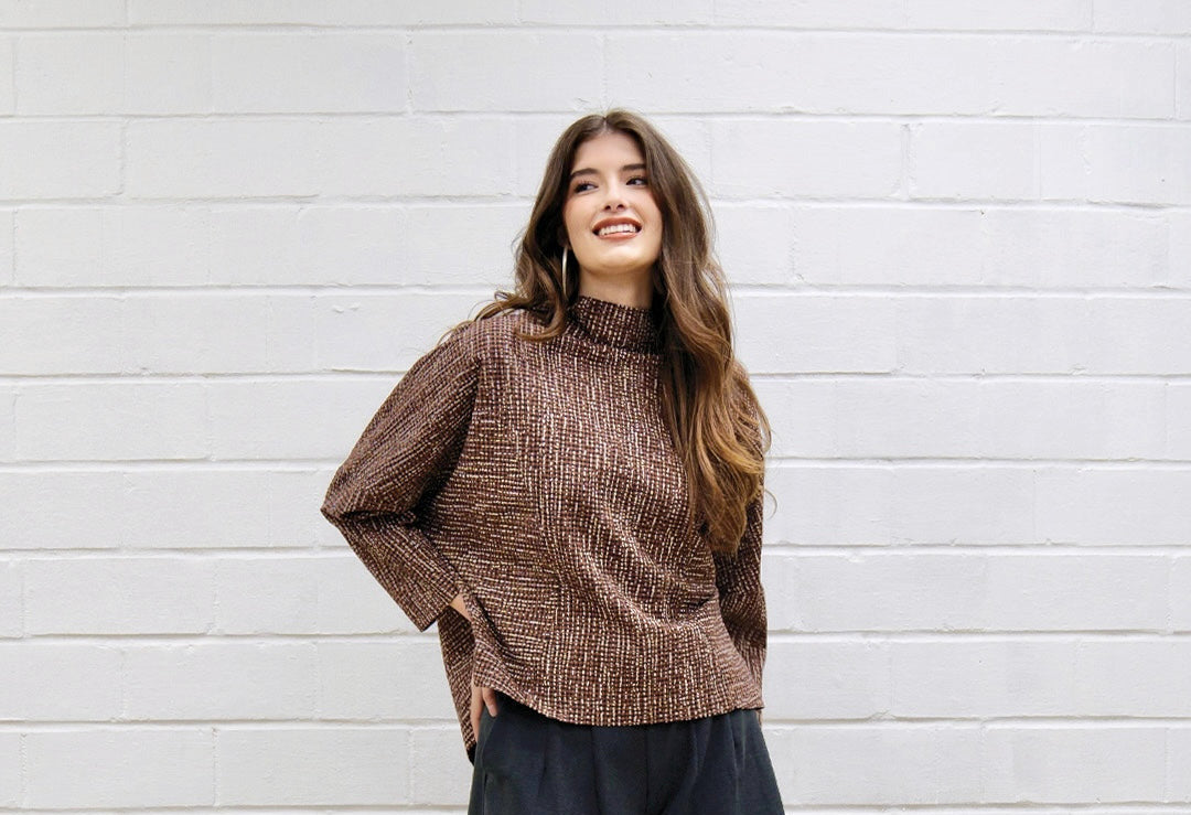 woman in a brown and white striped top with black pants