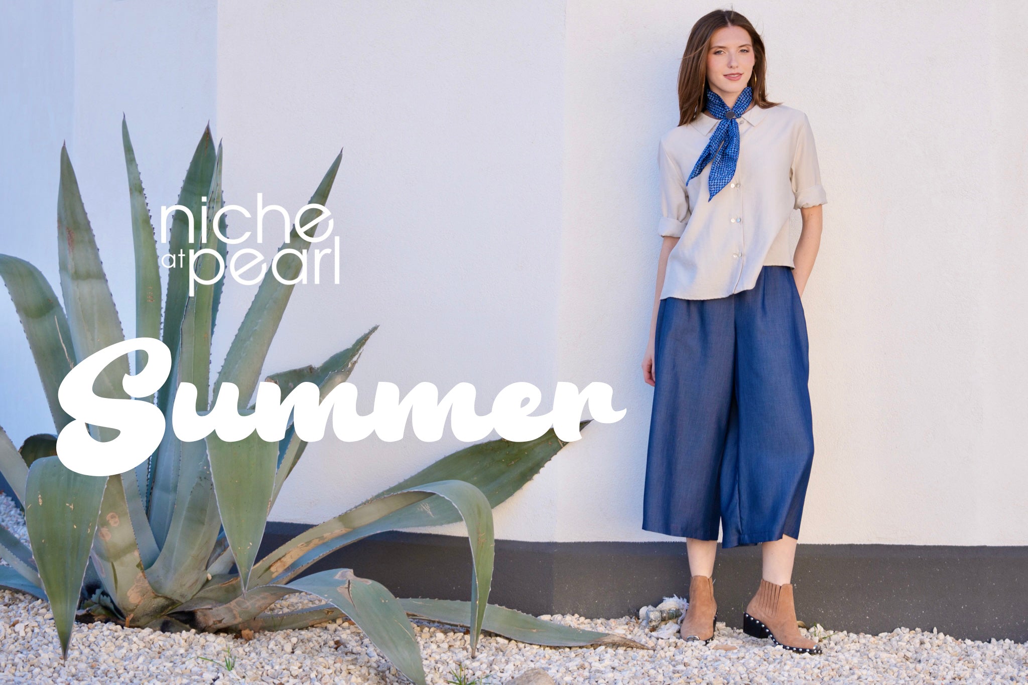 Woman in a light blouse and blue pants standing next to a plant with 'niche pearl' branding and the word 'summer'