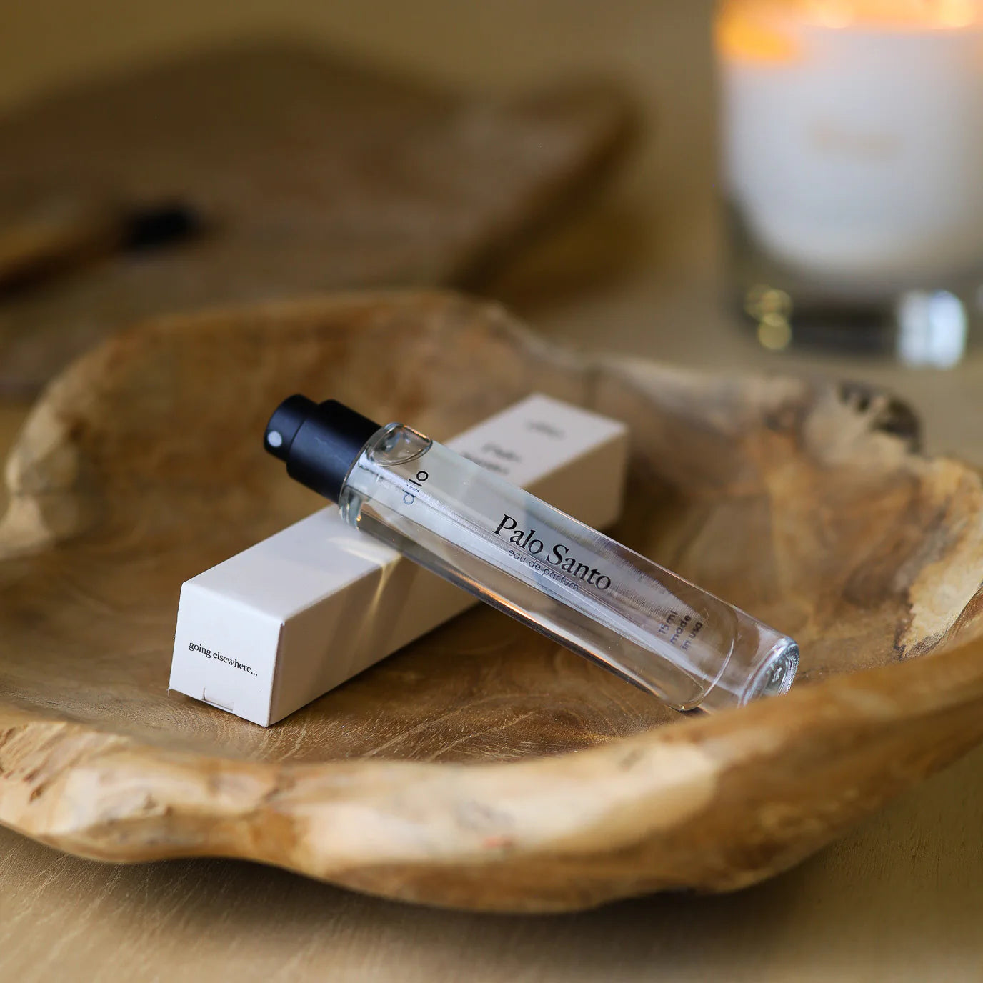 palo santo scented perfume bottle with packaging on wood tray