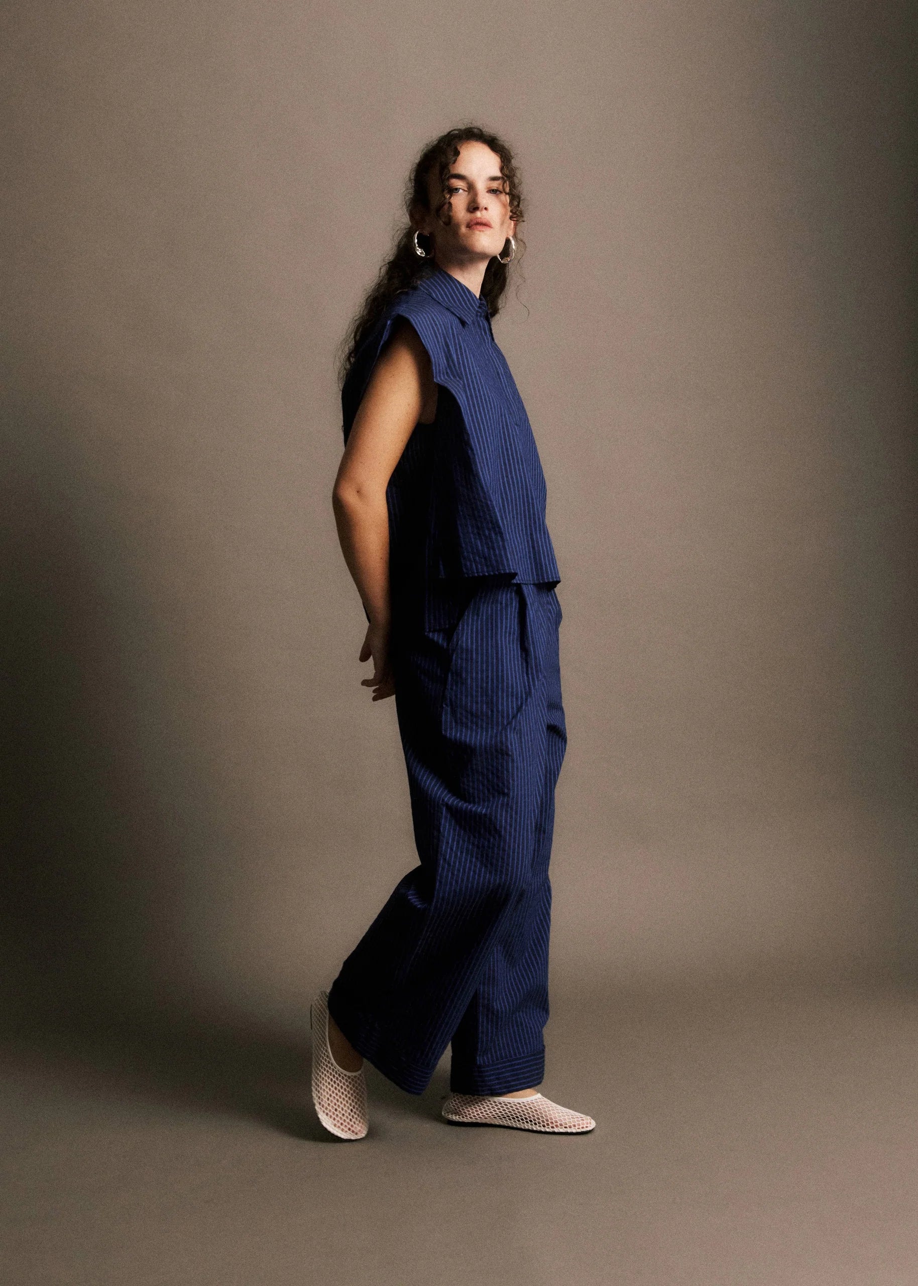 Woman wearing a blue outfit against a plain background