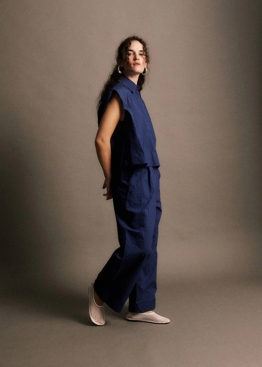 Woman wearing a blue outfit against a plain background