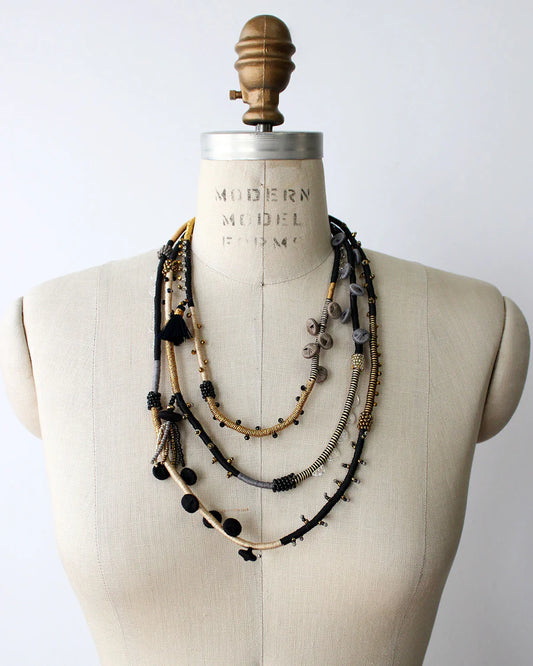 Necklace displayed on a mannequin bust with a plain background