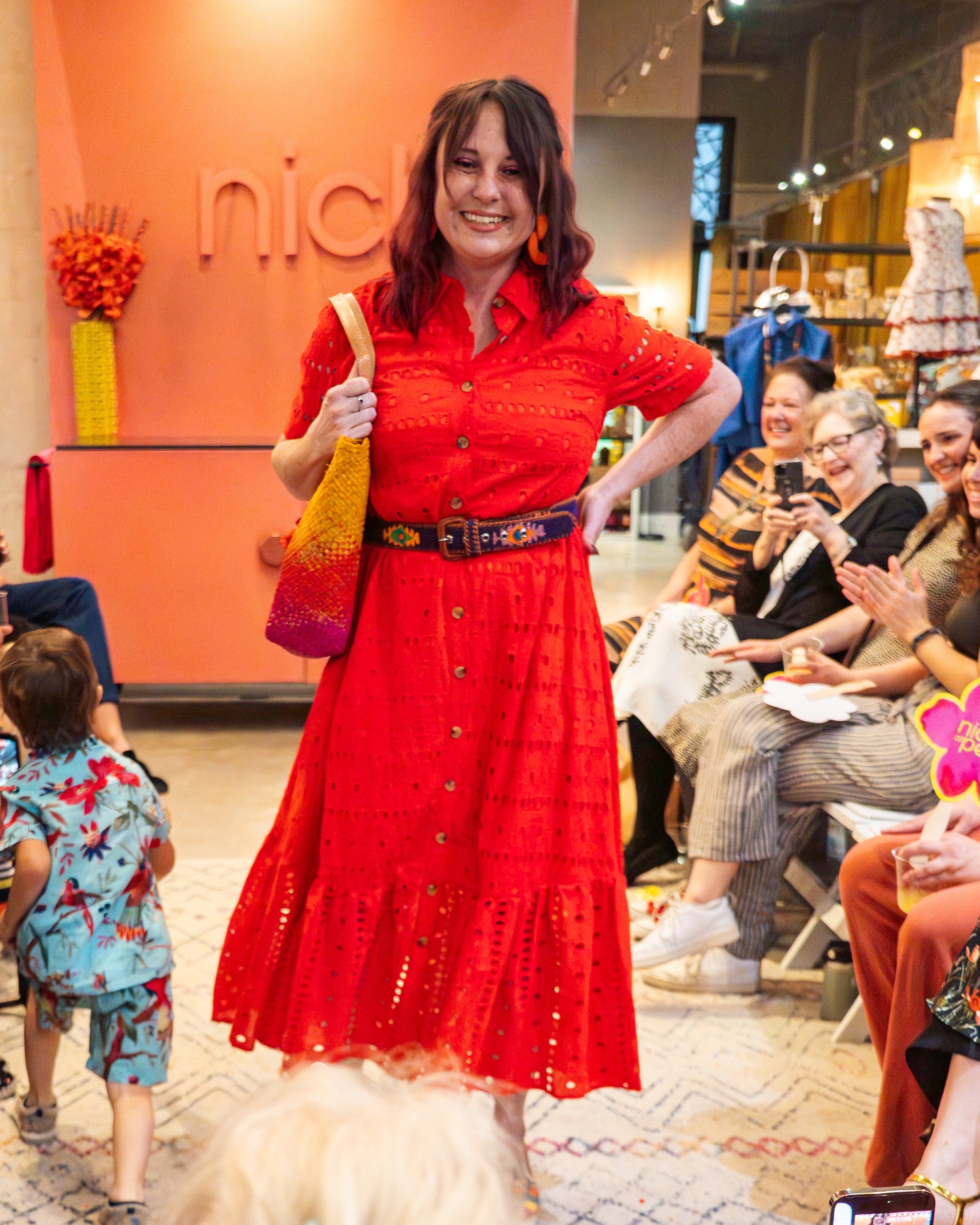 Woman in a red dress posing on runway in a store