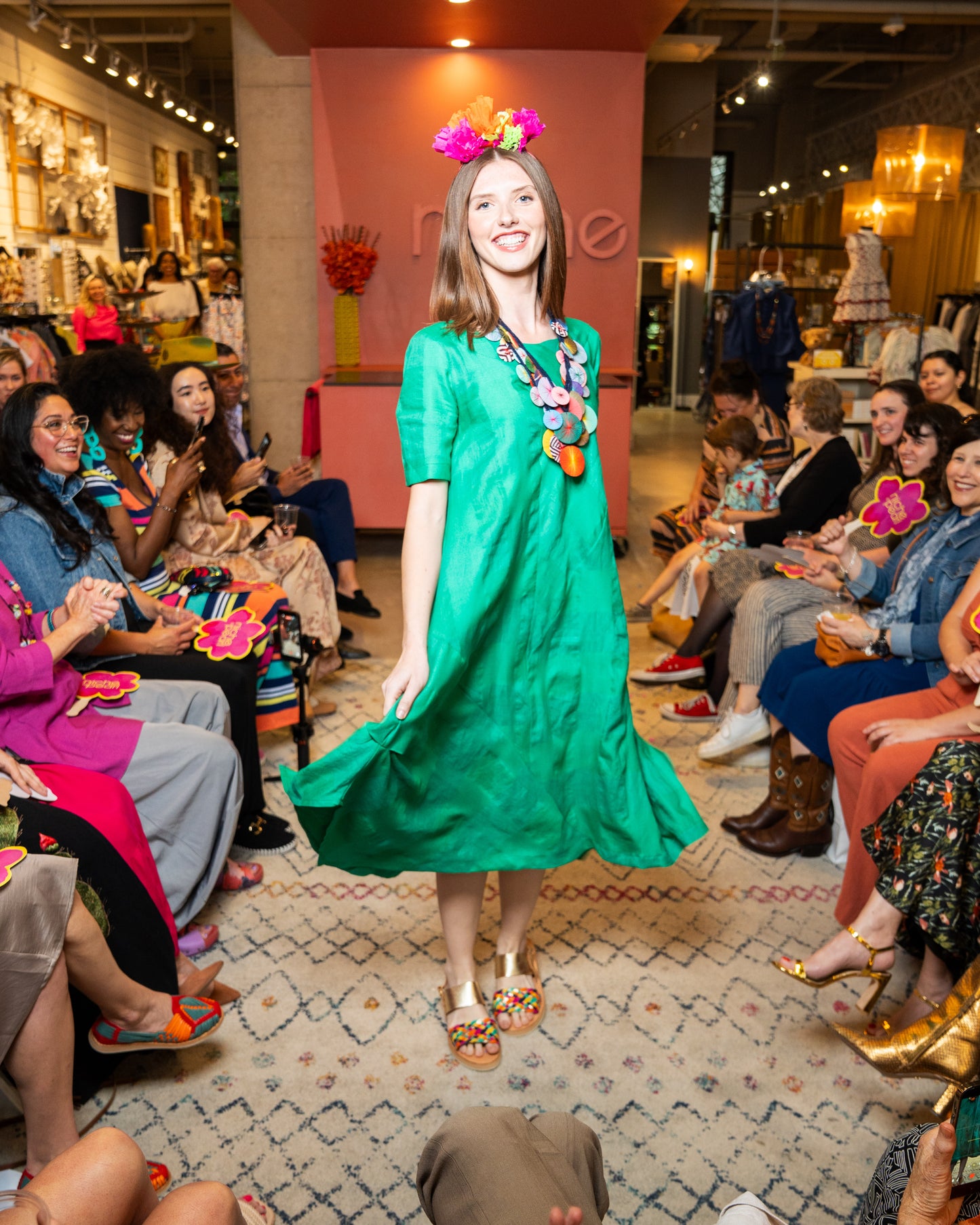 Woman in a green dress with colorful accessories at an event