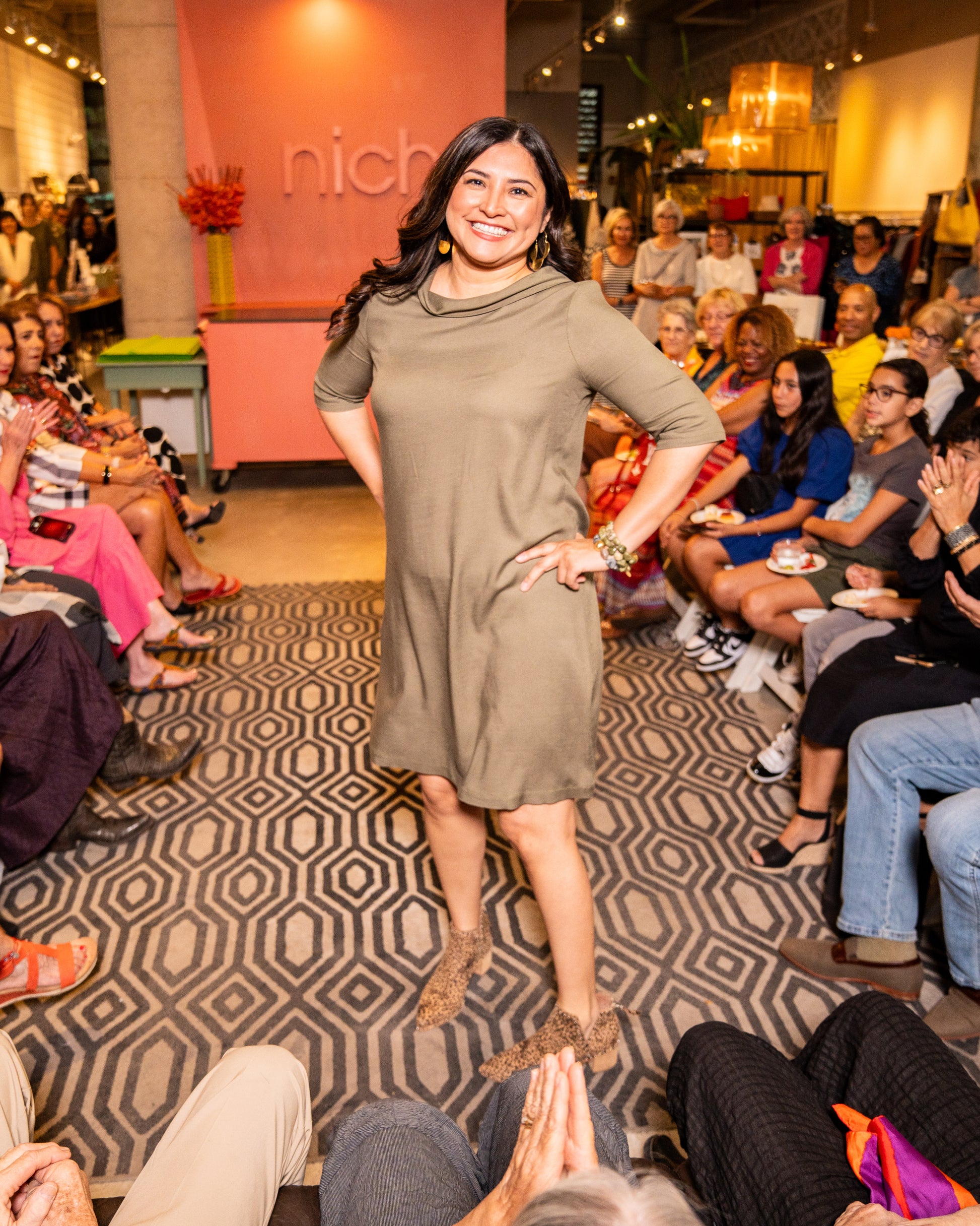 model wearing knee length olive green dress  with elbow length sleeves 