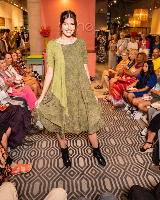 model in a black and green striped dress with a contrasting panel, 3/4 sleeves, a full body and splits on the side seams