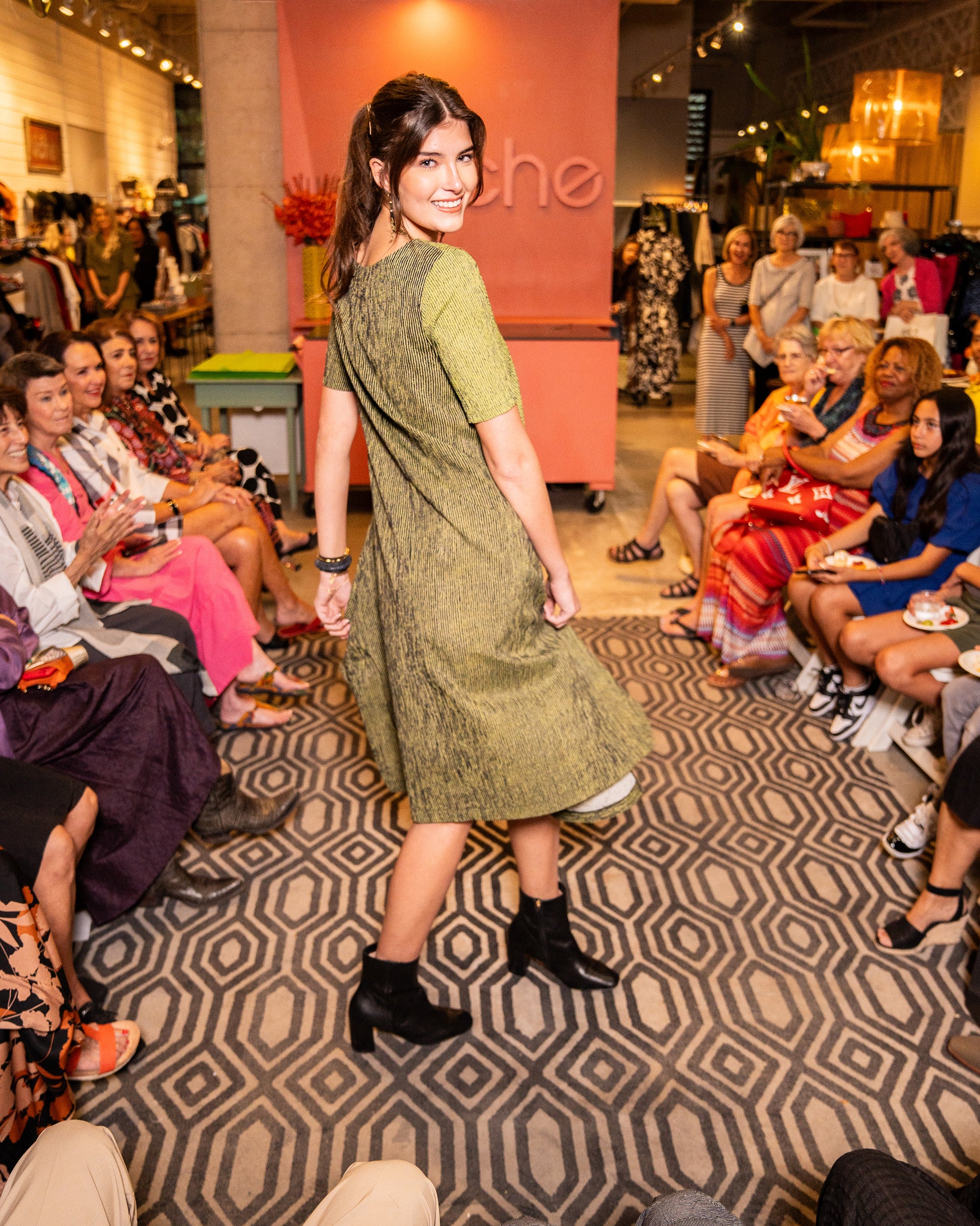 model in a black and green striped dress with a contrasting panel, 3/4 sleeves, a full body and splits on the side seams