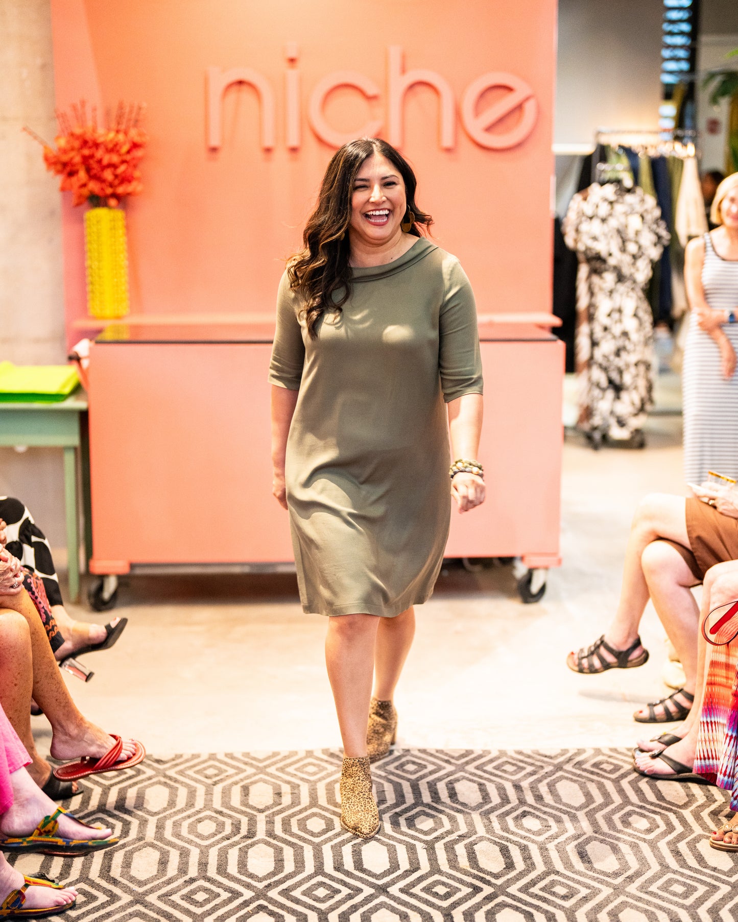 model wearing knee length olive green dress  with elbow length sleeves 