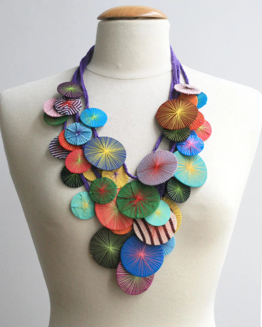 Colorful necklace on a mannequin against a white background