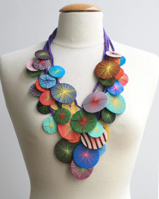 Colorful necklace on a mannequin against a white background