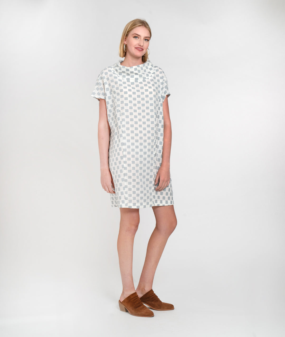 model in a grey and white checker board print boxy dress with a cowl neck and princess seams