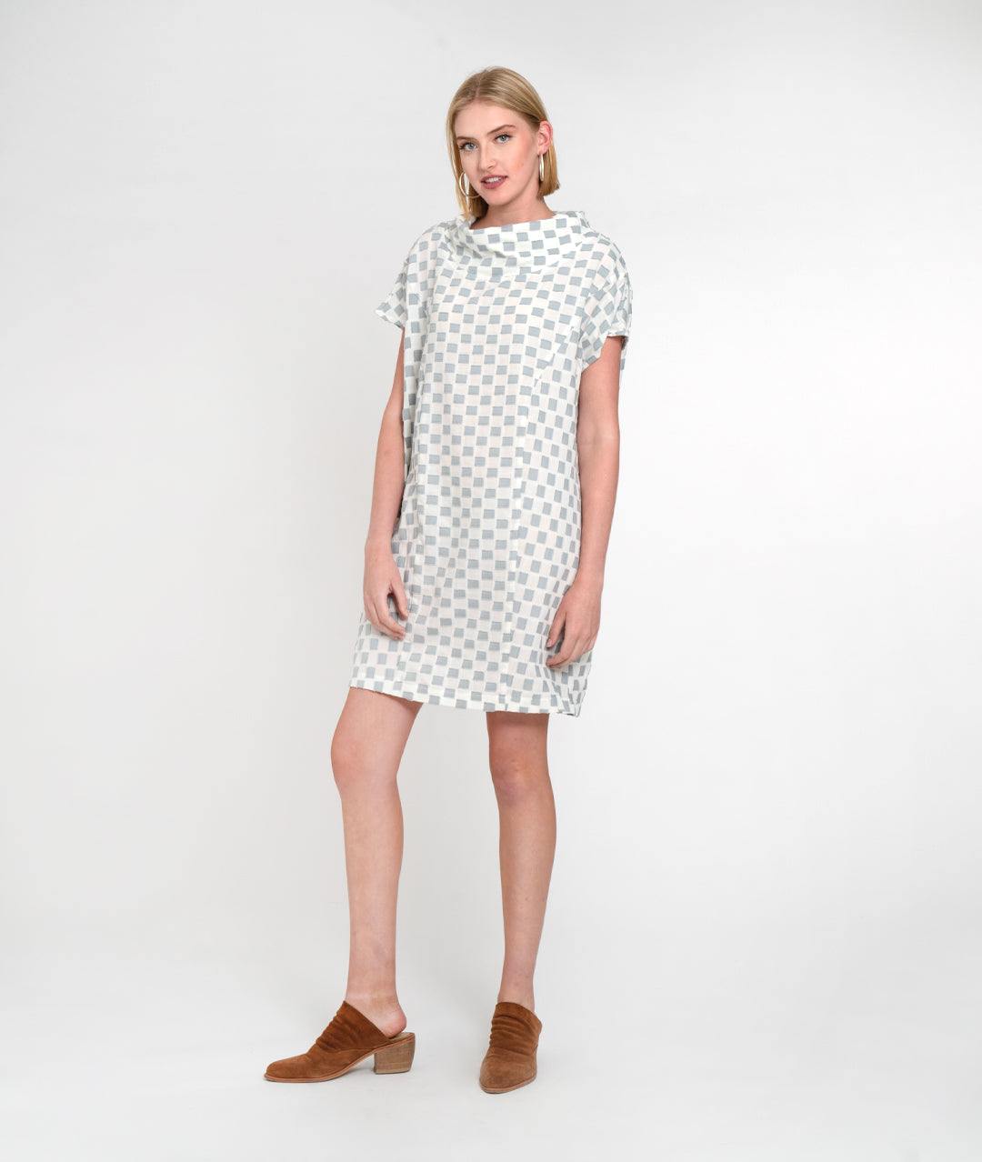 model in a grey and white checker board print boxy dress with a cowl neck and princess seams