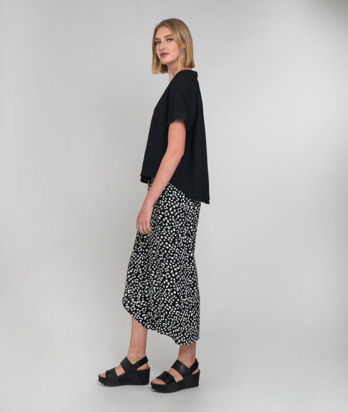 model in a wide leg black and white dot print pant with a faux wrap front, worn with a solid black boxy top
