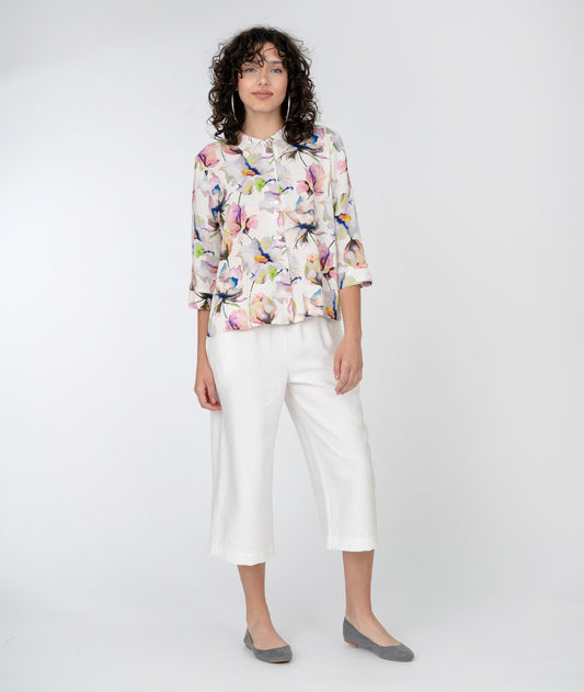 model in a cropped wide leg white pant with a floral print button down blouse with a 3/4 sleeve