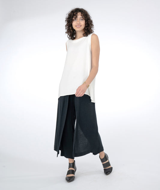 model in a long white tank with a slim black pant with flowing side panels