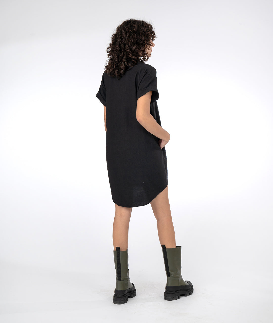 model in a boxy black dress with short cuffed sleeves and a vneck