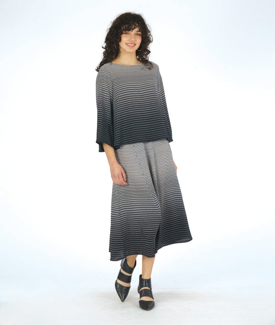 model in a boxy pullover top in a black to white grid print gradient. worn with a matching extra wide leg pant in a matching fabric