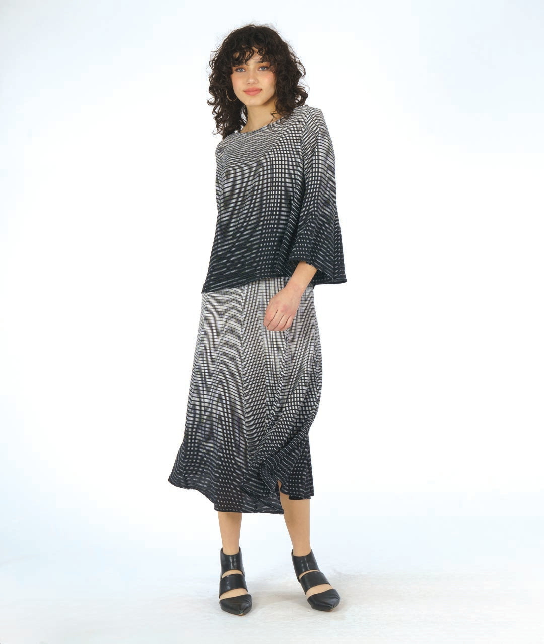 model in a boxy pullover top in a black to white grid print gradient. worn with a matching extra wide leg pant in a matching fabric