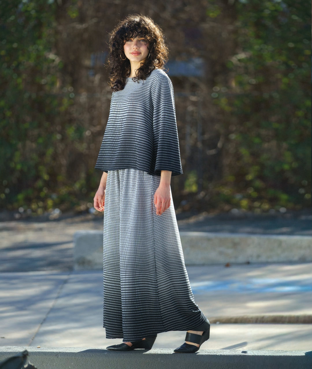 model in a wide leg pant with a matching boxy top, both in a black and white gradiant print