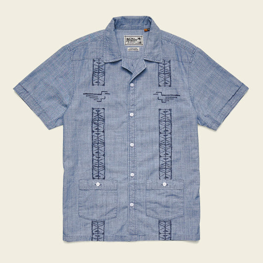 Blue short-sleeve shirt with geometric patterns on a beige background