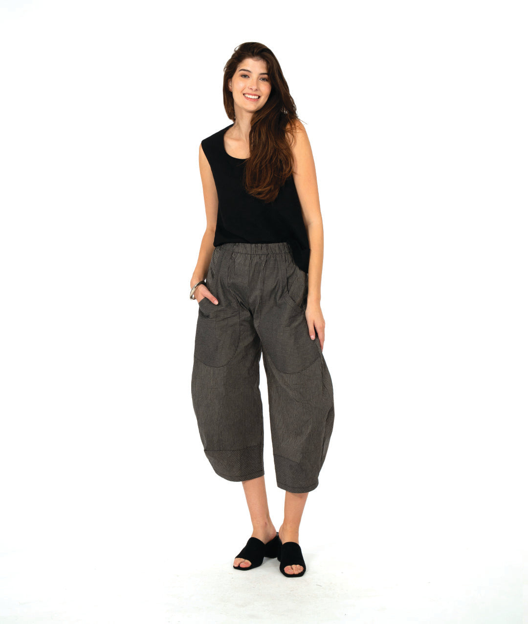 model in a solid black tank top with a grey and black stripe barrel leg pant with oversized contrasting stripe pockets