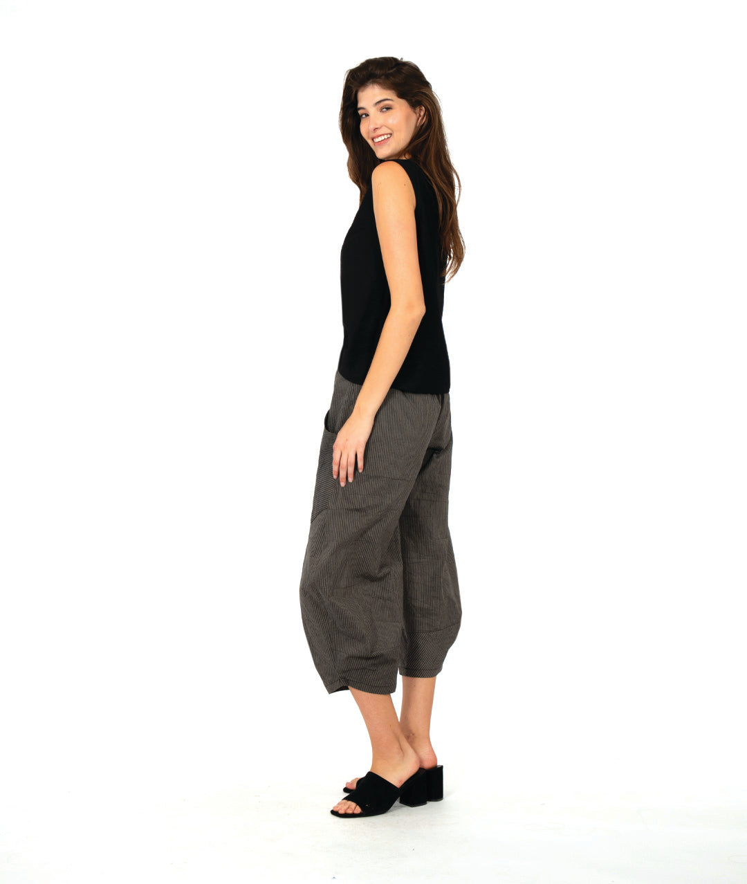 model in a solid black tank top with a grey and black stripe barrel leg pant with oversized contrasting stripe pockets