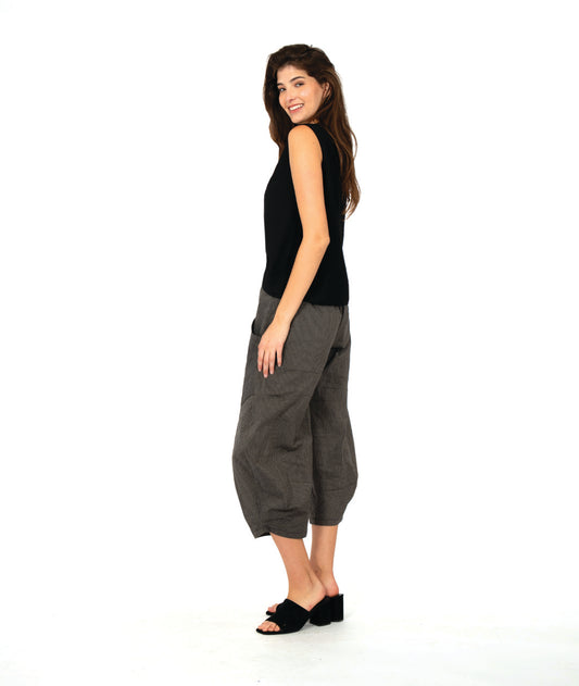 model in a solid black tank top with a grey and black stripe barrel leg pant with oversized contrasting stripe pockets