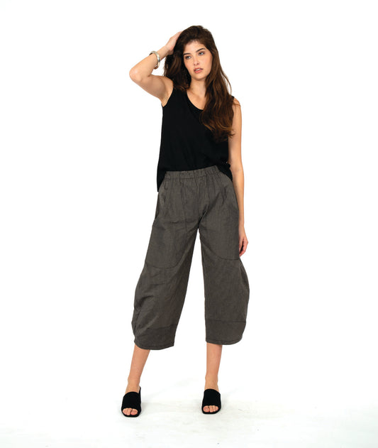 model in a solid black tank top with a grey and black stripe barrel leg pant with oversized contrasting stripe pockets