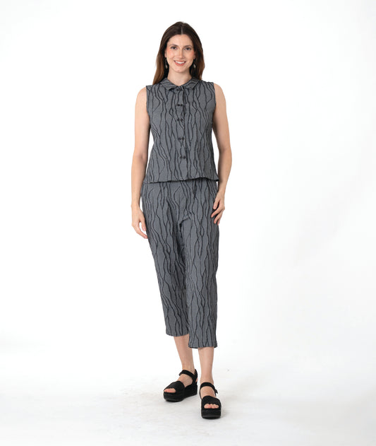 A woman modeling a matching sleeveless top and cropped pants set in a dark gray and black wavy pattern, paired with black platform sandals, against a plain white studio background.