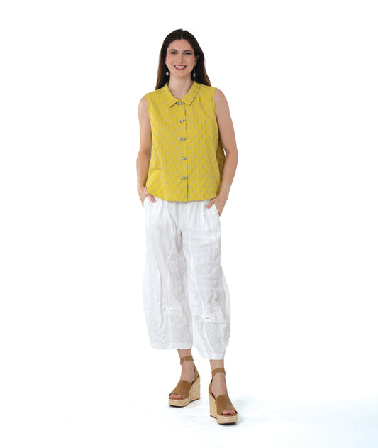 model in a yellow two toned sleeveless blouse, with a textured white pant with tucks below the knee 