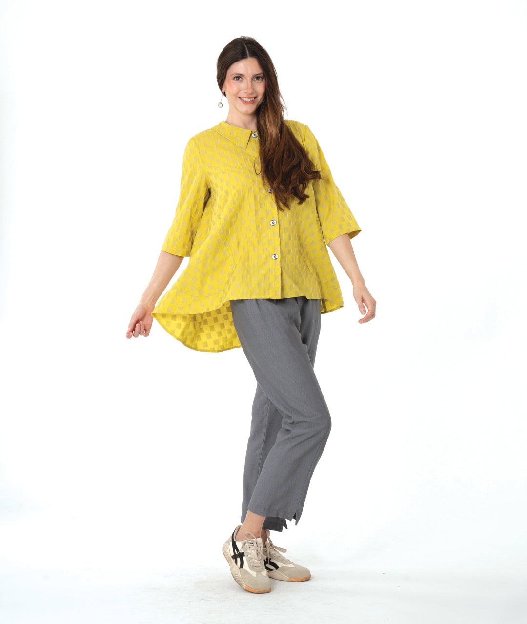 model in a yellow two tone checker board print button down blouse with 3/4 sleeves and a full body. worn with a slim grey pant