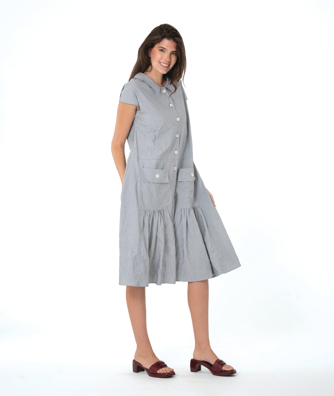 grey and white pinstriped button down dress with a dropped waist, cap sleeves, squared hip pockets and contrasted red stitching at the buttons.