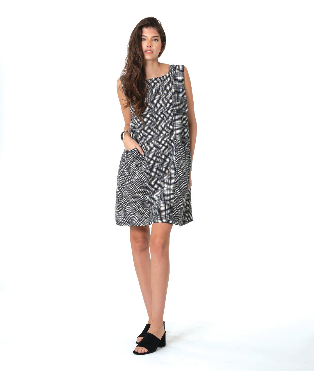 model in a black, white and grey plaid sleeveless shift dress with a squared collar
