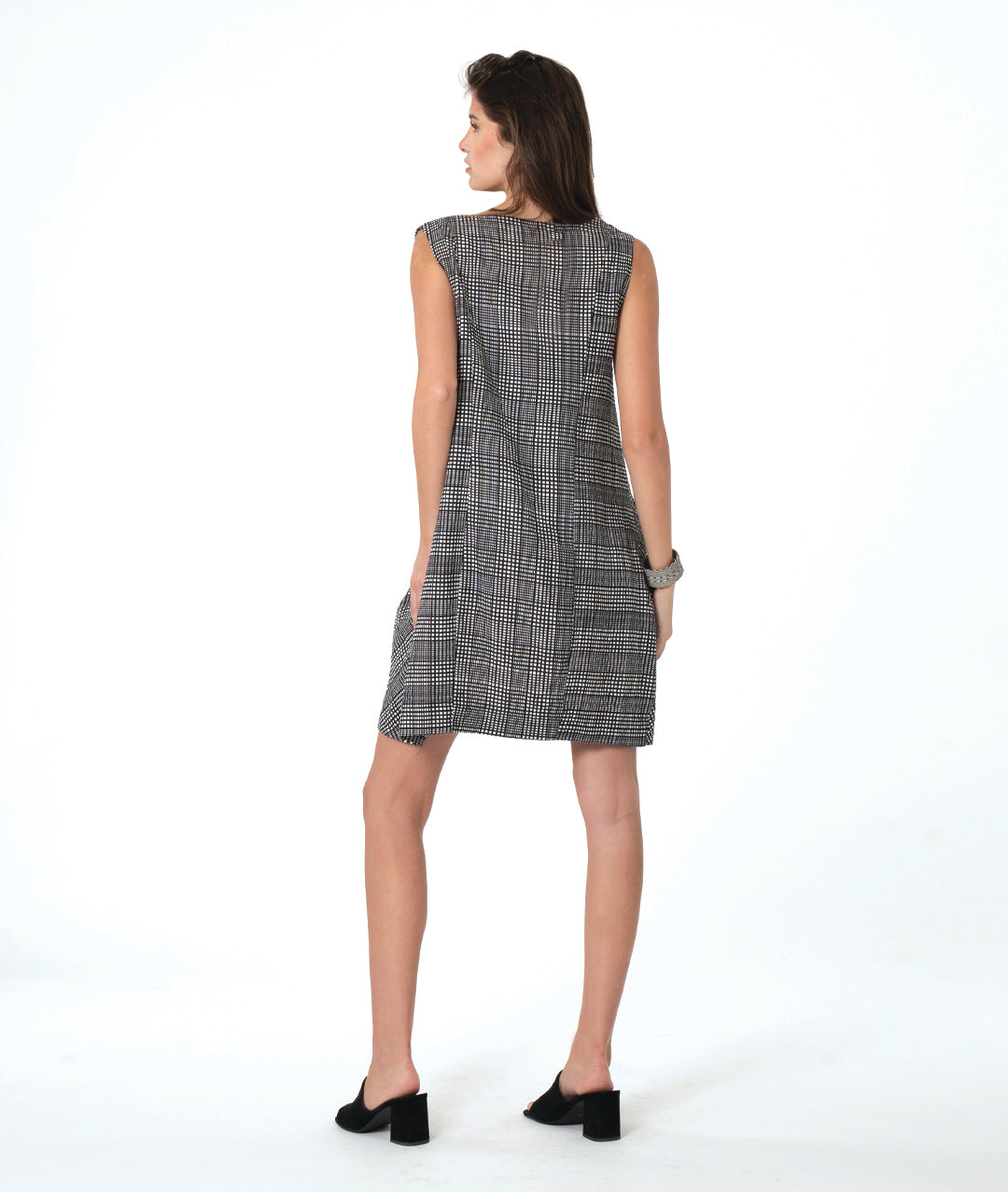 model in a black, white and grey plaid sleeveless shift dress with a squared collar